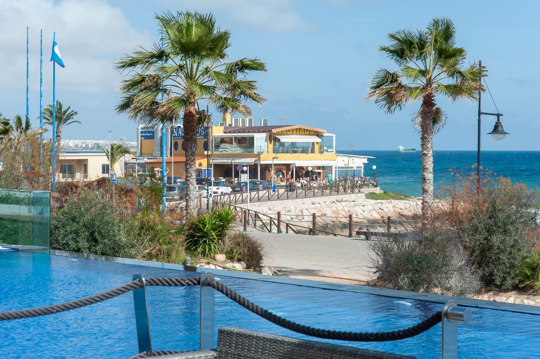 Oversiktsbilde av en restaurant ved en strand med palmer